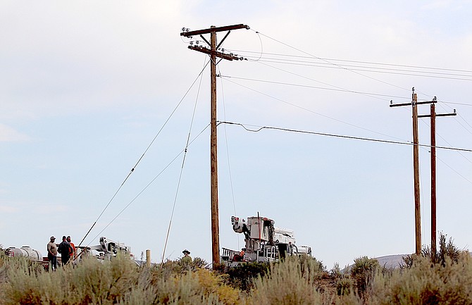 Power company workers above Plymouth Drive in Indian Hills on Saturday morning.