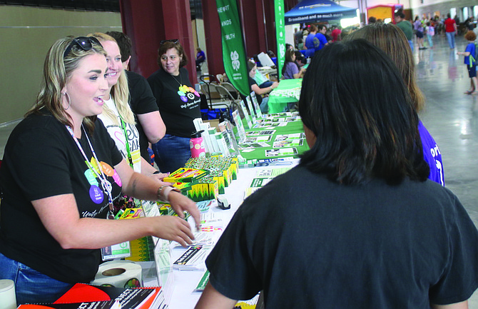 Kaitlin Ritchie, left, talks to a parent at the Churchill County School District table during the 2023 Fallon Community Day.