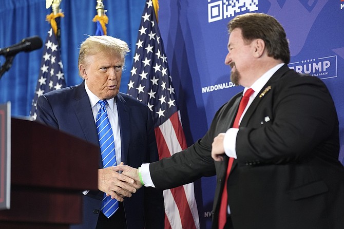 Nevada GOP chair Michael McDonald, right, shakes hands with Republican presidential candidate former President Donald Trump at a campaign event on Jan. 27, 2024, in Las Vegas.