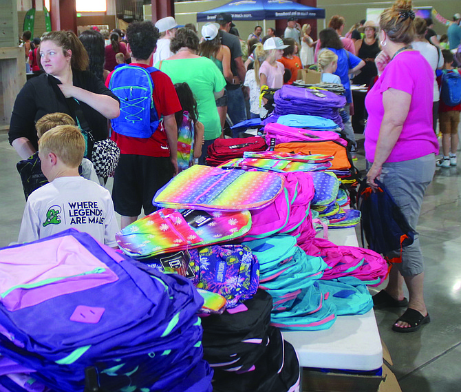 Parents and students peruse a stack of backpacks at a previous Fallon Community Day.