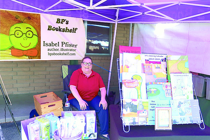 Isabel Phister is selling her books at the Just a Drop Farmer’s Market. She unveiled her new mobile bookshelf on Wednesday.