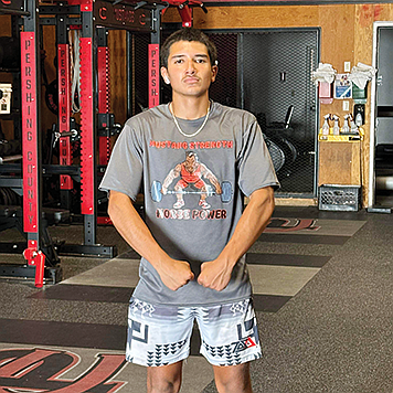 Ramon Sanchez displays his Mustang Strength tee shirt, designed by coach Mike Brooks.