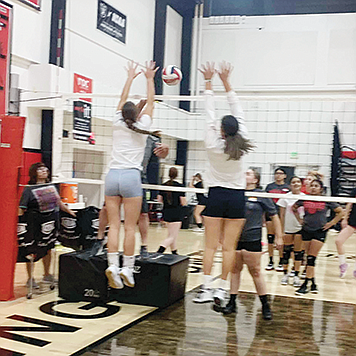 Mustang seniors Raegan Burrows and Aaliyah Allen block during a volleyball drill.