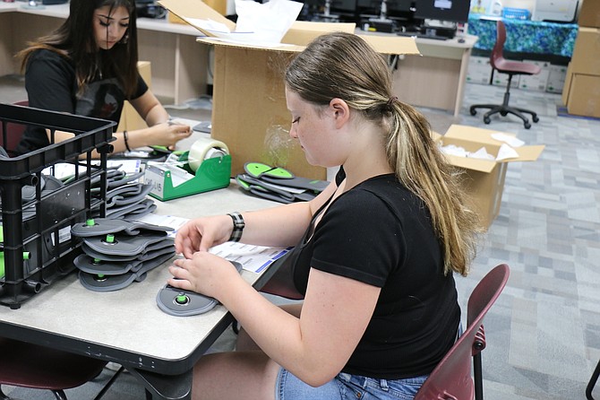 Carson High School sophomore Ashlynn Woodyard, a member of the school’s Blue Crew, volunteers to prepare the school’s new Yondr cell phone pouches for students before school starts on Aug. 19.