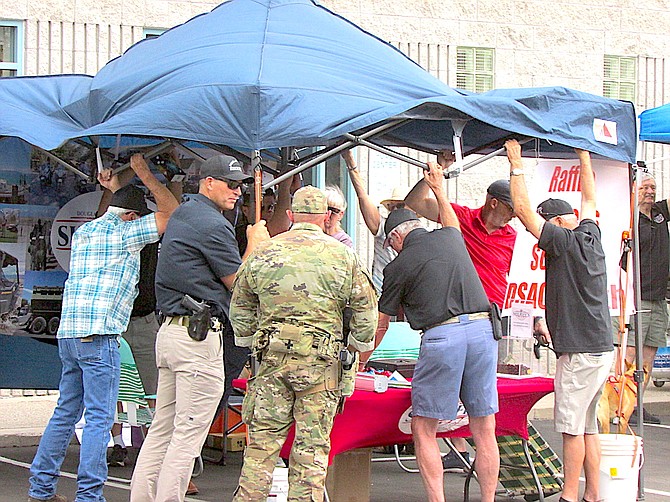 National Night Out attendees including vendors and Sheriff Dan Coverley helped hold down tents when gusts of winds threatened the event.