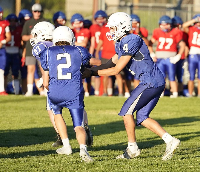 Carson High quarterback Drake Hardcastle (4) hands off to running back Shane Robinson (2) while Ean Thomas (27) looks to lead the blocking. The Senators open their season Saturday at home against Canyon Springs.