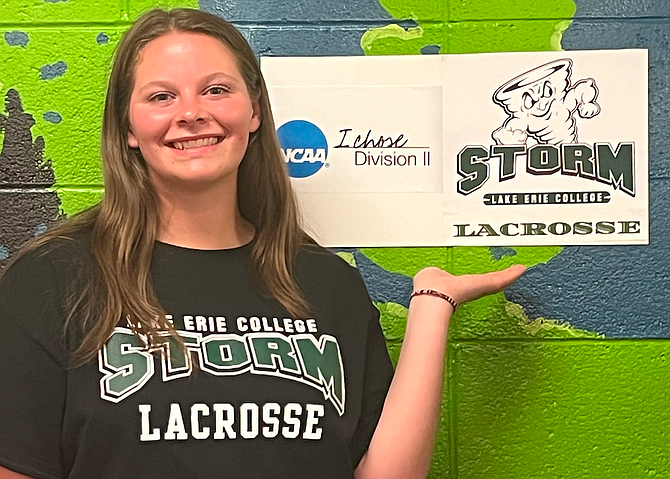 Douglas High’s Rachel Rose poses for a photo next to her nameplate after signing with Lake Erie College for women’s lacrosse. Rose was a three-time all-league recipient at attack and was named the 2024 Jackie Pitts award winner.