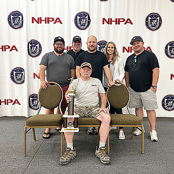 Surrounded by friends and family, Dave Skoglie displays his trophy from the world horseshoe championship.