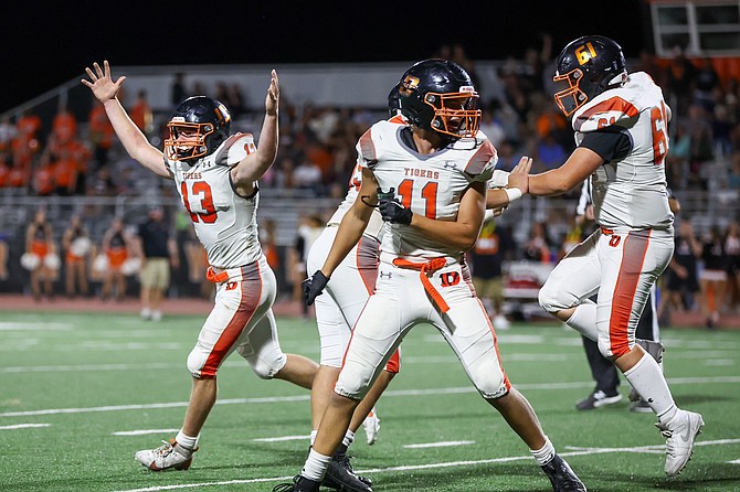 Douglas High's Brenton Weston (13) celebrates alongside teammates Michael Sinclair (11) and Camden Dufloth (61) after Weston's game-winning 31-yard field goal gave the Tigers a 16-13 win over Fernley as time expired.