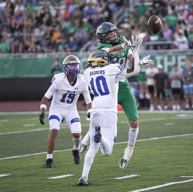 Fallon’s Wyatt Peek tries to catch a pass from Matthew Bird while Reed’s Xavier Huizar defends the play during Friday's game.