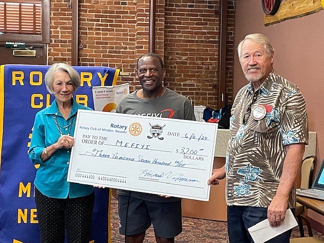 Minden Rotary Club Members Milly Seibel and Howard Vipperman stand next to MEFIYI's JoJo Townsell, middle, while posing for a photo.