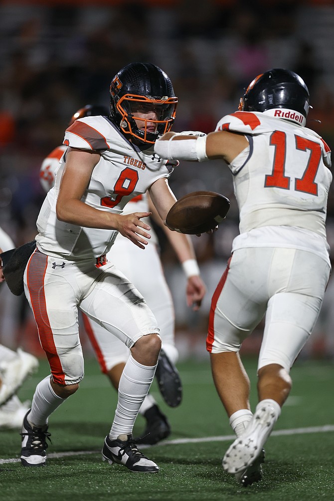 Jackson Ovard (9) looks to hand the ball off to Evan Youmans (17) against Fernley last week. Douglas High School football fell to Elko Friday night, 18-16.