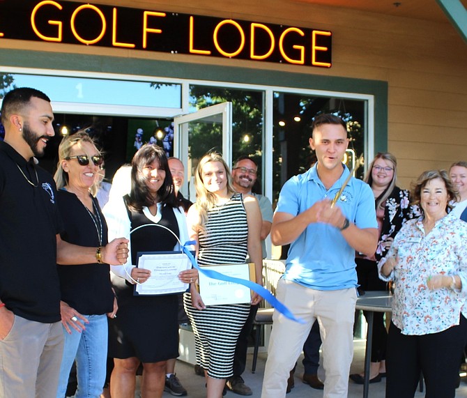 Golf Lodge owner Alex Emmons (second from right) successfully cut the Chamber of Commerce’s ceremonial ribbon to open his new business venture, amid cheers from local authorities, friends and family.