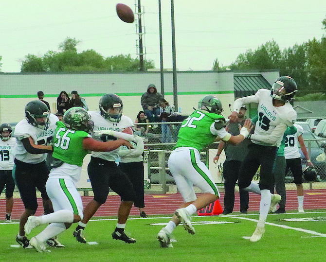 Greenwave rushers Caleb Edgmon (52) and Trevor Hyde (56) pressure North Valleys quarterback Mikole Almond (15).