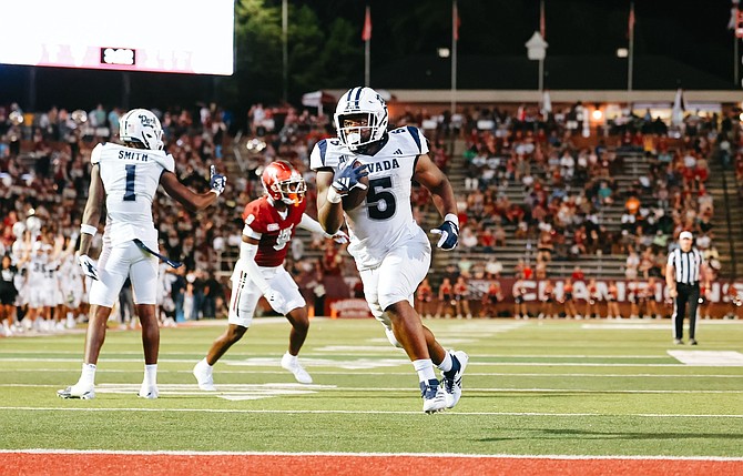 Nevada’s Patrick Garwo scores on a short run Saturday against Troy.