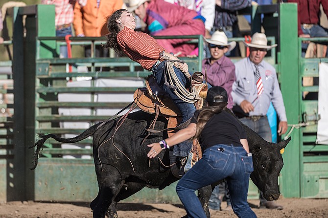 A bullrider hangs on at the 2023 Douglas County Rodeo.