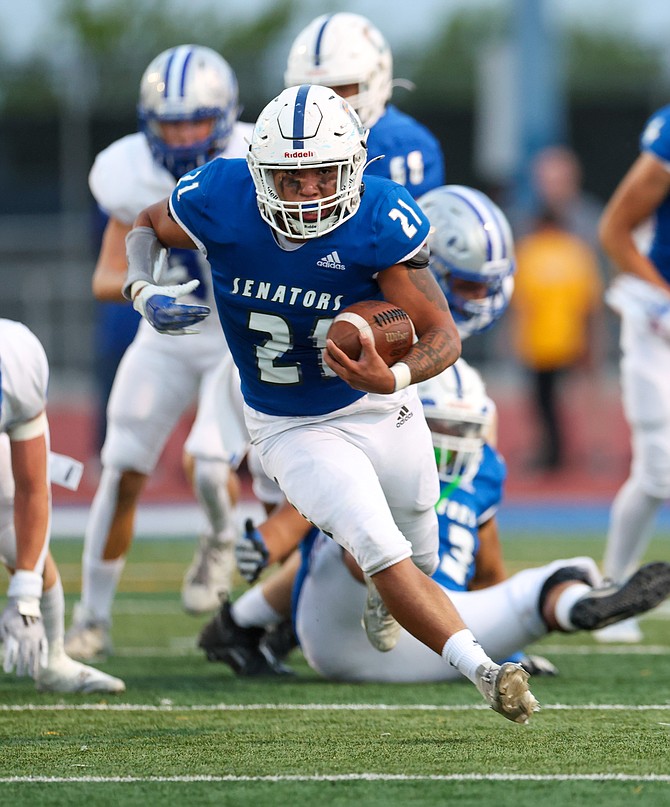 Carson High running back Christian Rey (21) breaks free from McQueen defenders Friday night at home. Rey and the Senator ground game accounted for nearly 400 yards rushing in a 31-28 win over the Lancers.