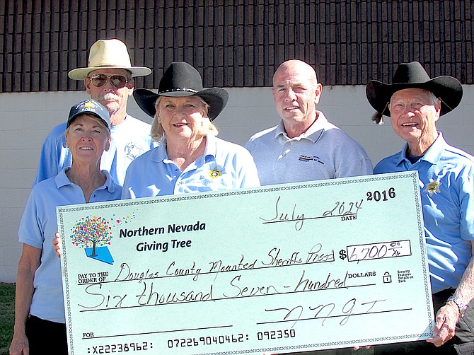 Douglas County Sheriff’s Mounted Posse Jeff Regan, Amy Regan, Mo Parga, Under Sheriff Ron Elges, and Dick Clark stand with a check presented by the Northern Nevada Giving Tree Tuesday.