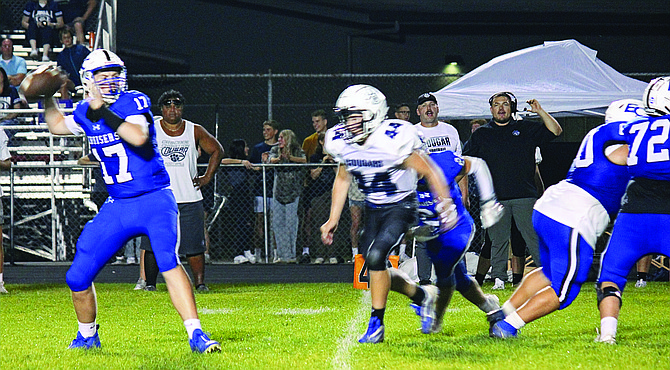 Eatonville's Cole Fowler drops back to pass as a Cascade Christian defender bears down on him. Fowler would lead his team to an exciting victory in the Cruisers' season opener.