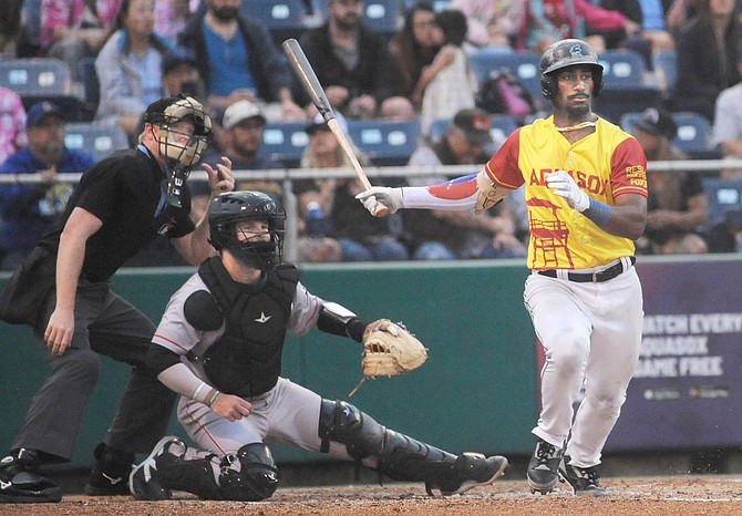 Hitting a flyball into right field, Everett AquaSox batter Lazaro Montes takes off toward first base while Spokane Indians catcher Cole Messina and umpire Shane Sullivan watch during early game action in the Sox’s 7-5 loss at Funko Field in Everett on Saturday, Sept. 7. Everett’s overall season record was 64-68.