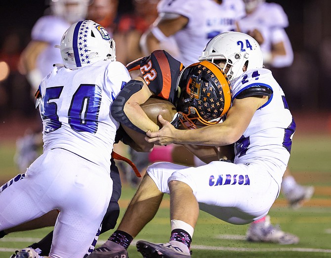 Carson High’s JT Heaton (24) wraps up a Douglas ball carrier during The Rivalry Game last season. Heaton and the Senators are looking to reclaim the game’s huge trophy after losing last year in Minden.