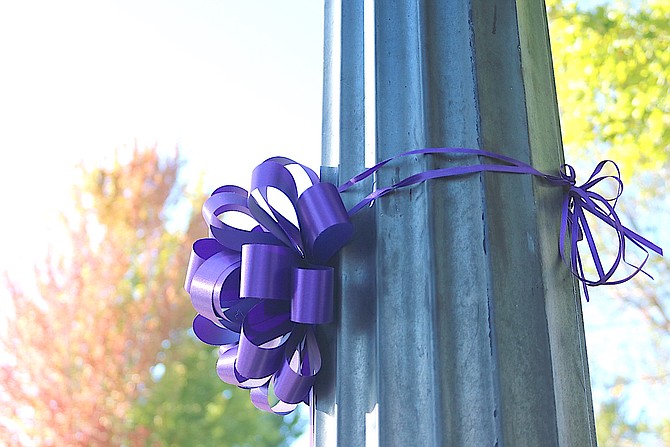 A purple ribbon adorns a light pole at Heritage Park on Thursday morning in honor of Suicide Prevention Month. The park will be the location of an event between Healing Arenas and Suicide Prevention Network on Friday.