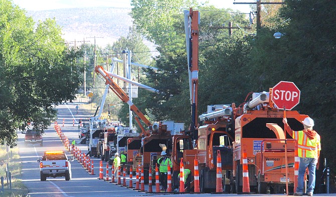 Workers trim trees around power lines along Jacks Valley Road just north of Genoa on Friday morning.