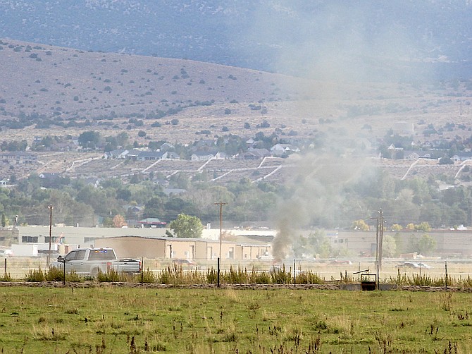 A Douglas County Sheriff's Office patrol vehicle heads for the scene of an airplane crash on Monday morning marked by the smoke plume.