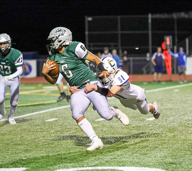 Carson High's Ezekiel Keechler (51) makes a diving tackle on Hug's quarterback Friday night in a 37-0 Senator win over the Hawks on Homecoming.