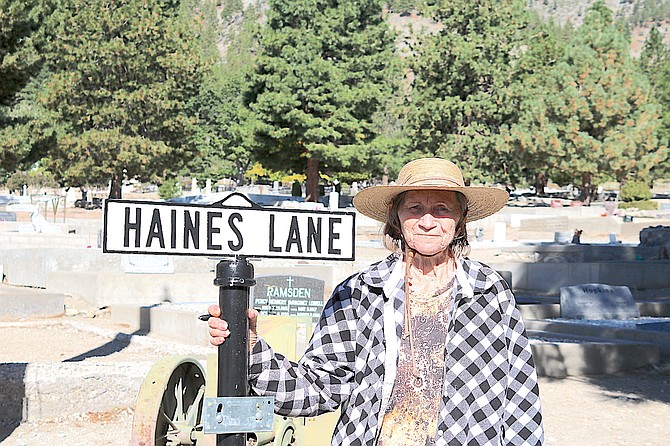 Carson Valley native Laurie Hickey stands next to the sign for Haines Lane, named after Sen. J.W. Haines. Hickey was conducting the Genoa Cemetery Tour on Saturday.