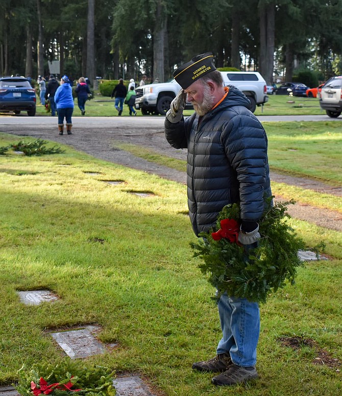 A member of Monroe’s VFW Post 7511 salutes a grave with wreath in hand at the IOOF Cemetery in Monroe in December 2023 as part of the VFW’s annual wreath placing to honor veterans in the cemetery.