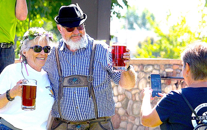 Four-time beer stein holding contest winner Sally Chaphart poses Sunday for a photo with second place winner Todd Kirchoff, who also won the costume contest.