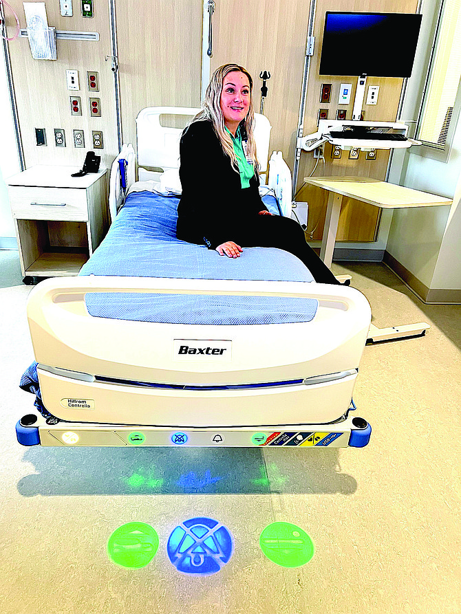 Nursing Manager Melissa Lynum sits on one of the patient beds that talk.