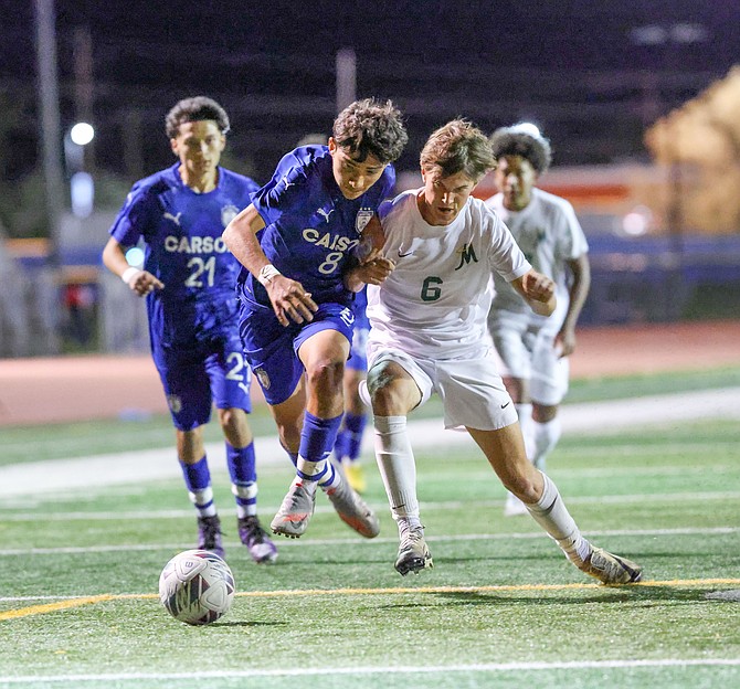 Carson High senior Jaden Gomez (8) and Bishop Manogue’s Kade Millard battle over possession, during the Senators’ 2-1 win at home over the Miners Wednesday.