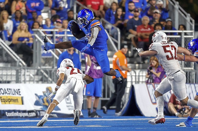 Boise State running back Ashton Jeanty hurdles Washington State defensive back Ethan O'Connor on a run in the second quarter of Saturday’s game.