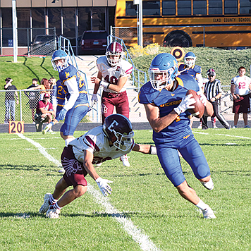 Lowry’s Anthony Monroy looks for room to run after a reception during Saturday’s game with Elko.