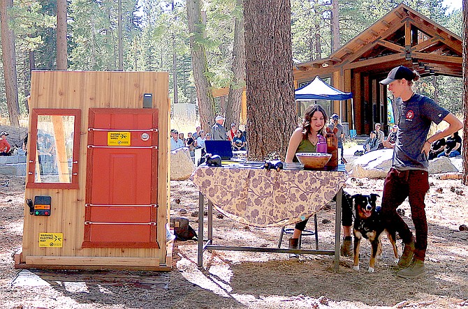 Kelsy and Joseph Pollard work the Bear Busters booth at the Bear Fest on Saturday at Spooner Lake State Park. The bungees and windows work with a door mat as part of a system that gives a bear a jolt if it tries to enter a home.