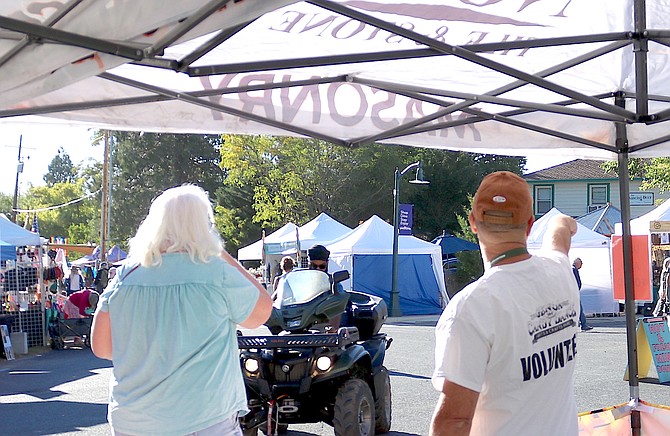 A volunteer directs a visitor to the Genoa Country Store across from the information booth in downtown Genoa on Saturday.