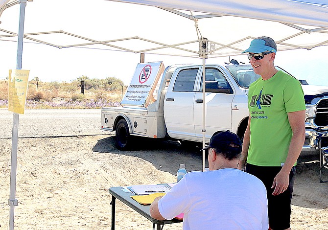 Johnson Lane resident Mike Nevius chats as Flyin' Brian Campbell signs the petition opposing the Painted Rock Mine on Tuesday.