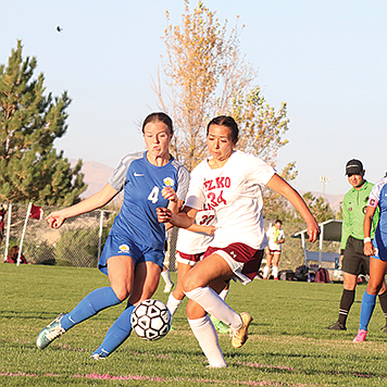 Lowry's Ava Swensen battles for control of the ball in Friday's 2-2 tie against Elko on Friday in Winnemucca.