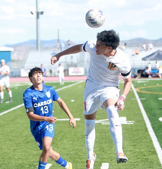 Douglas High’s Diego Diaz goes into the air for a header against Carson High on Saturday in Carson.