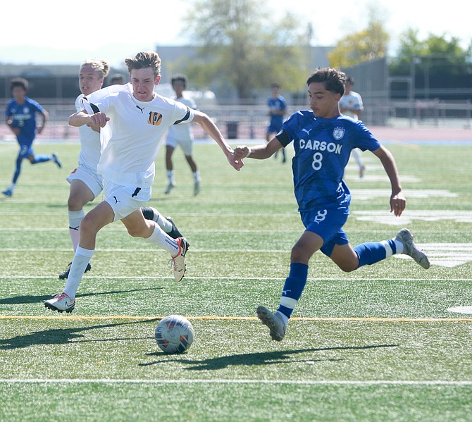 Carson High’s Jaden Gomez gets around a Douglas defender on his way to one of his five goals Saturday.