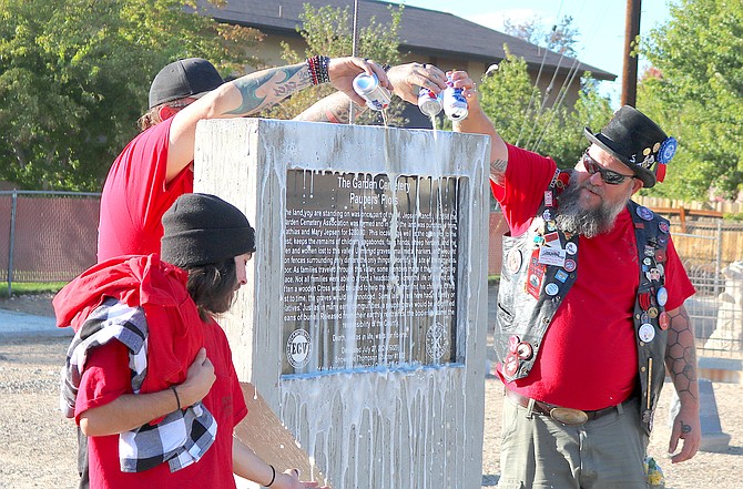 Robert Smith, Mike Mazzone and Noble Grand Humbug Jay ‘Banana Split’ Robinson anoint a historic marker with Pabst Blue Ribbon beer in the Garden Cemetery on Saturday.