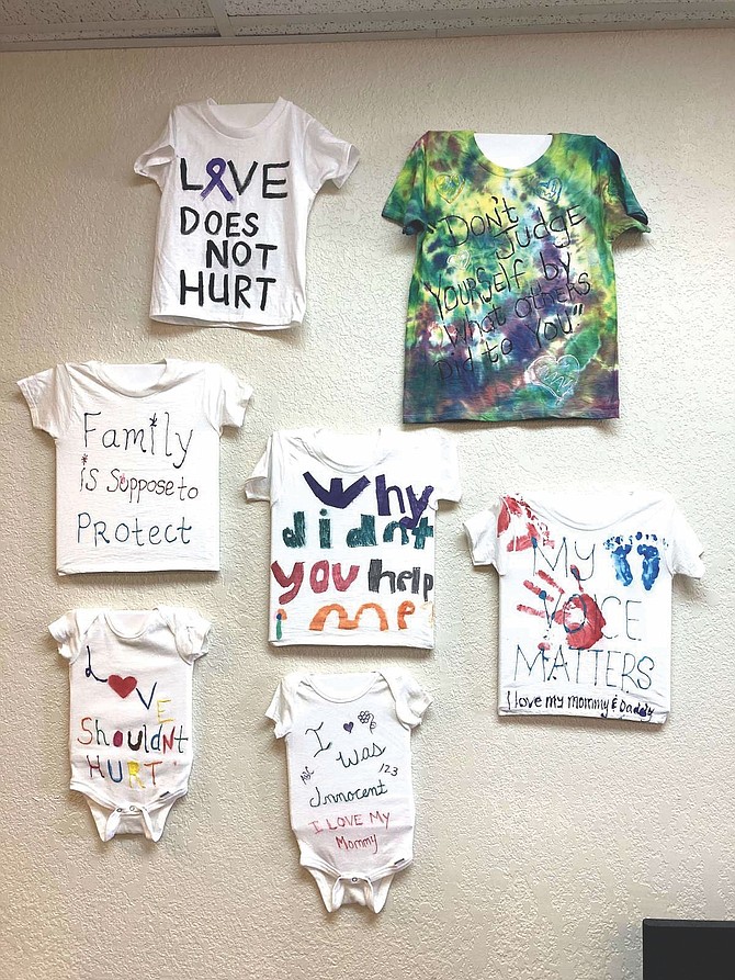 Shirts of hope for domestic violence survivors and in memory of its victims hang on the wall in the Domestic Violence Intervention Fallon offices.