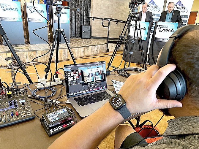 Brian Kulpa checks the sound for the May Town Hall Debate as moderators Bryce Clutts and James Settelmeyer prepare.