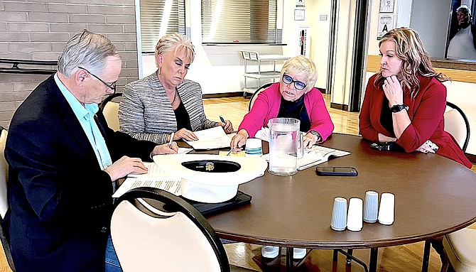 James Settelmeyer, Renea Louie, Bobbi Thompson work on their notes before Wednesday's Town Hall Debate while Clerk-Treasurer Amy Burgans looks on.