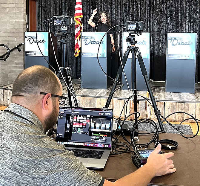 Main Street Gardnerville Executive Director Jen Tune participates in a sound check as videographer Brian Kulpa adjusts settings on Wednesday before the Town Hall Debate.