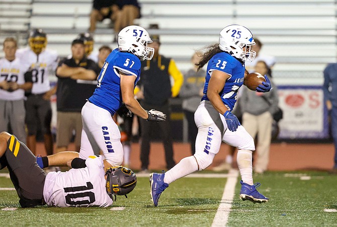 Carson High running back Angelo Macias (25) finds open space in front of him while lineman Cash Henry (57) moves to his next block.