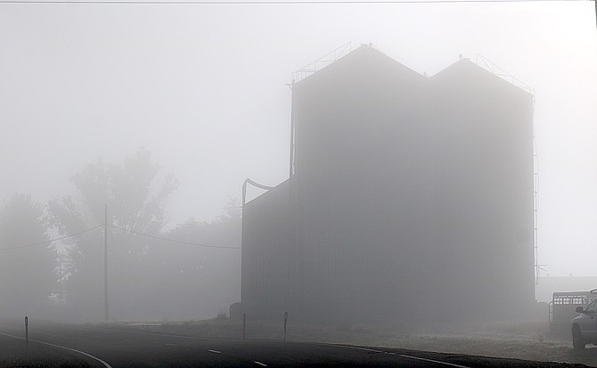 The Settelmeyer silos loom in the fog along Genoa Lane on Thursday morning. Conditions are clear but frosty out so far today.