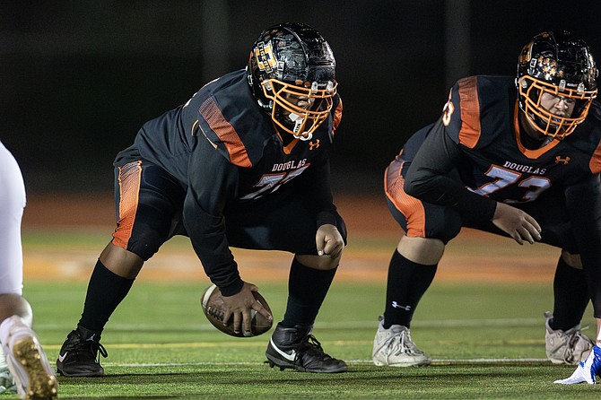 Douglas High offensive lineman Luiz Vega (77) and Curtis Haliwell (73) prepare to snap the ball Friday against Reed.